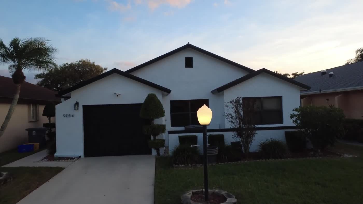 The same Boca Raton home after exterior painting with a light finish and dark accents